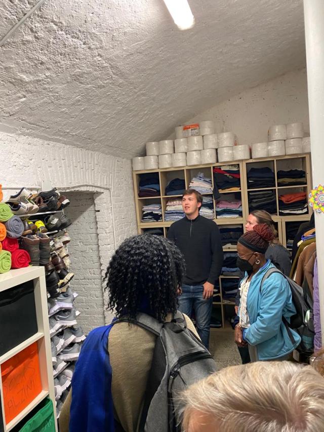People tour supply room of refugee help center