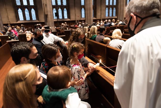 Families light their baptismal candles in Trinity Church on All Saints Sunday 2021