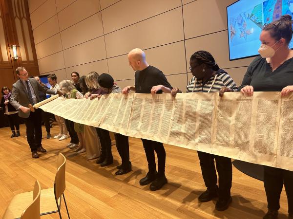 Rabbi Darren Levine rolls up a Torah scroll held by Into the Word participants, February 1, 2024