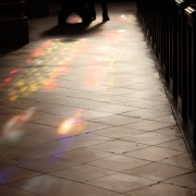 Colorful, stained-glass—filtered light shines on the stone floor of Trinity Church