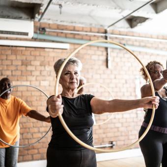 People exercising with hula hoops.