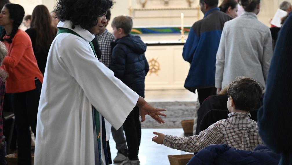 The Rev. Winnie Varghese greets a child during a family service at St. Paul's Chapel