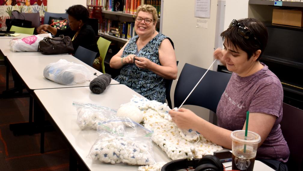 Trinity Knitters smiling and working in the Parish Center