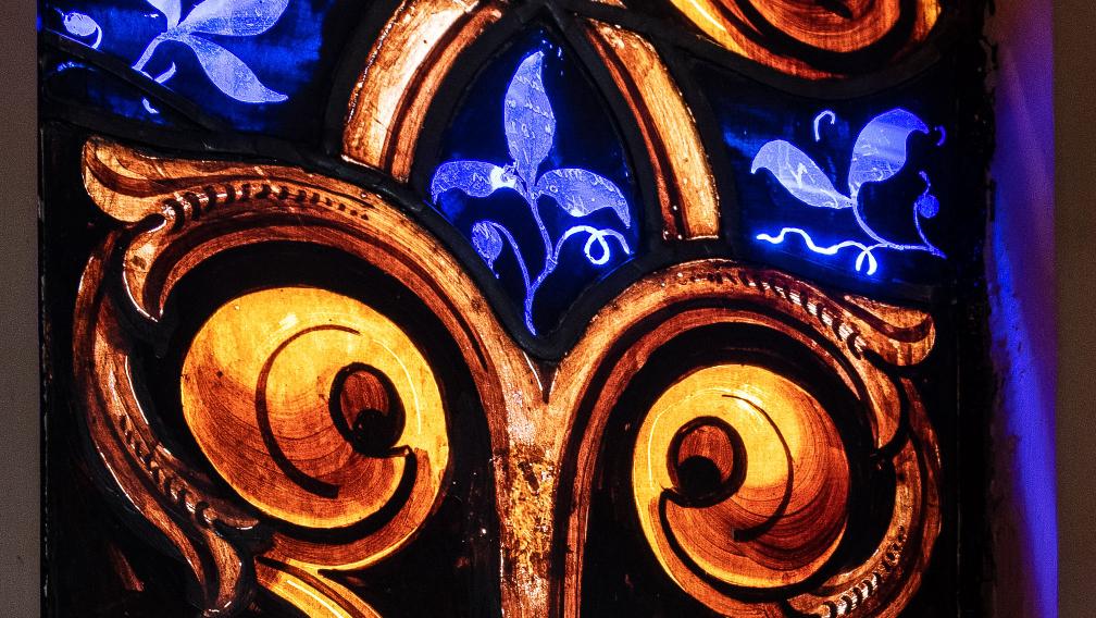Stained glass with gold swirls and blue plant tendrils
