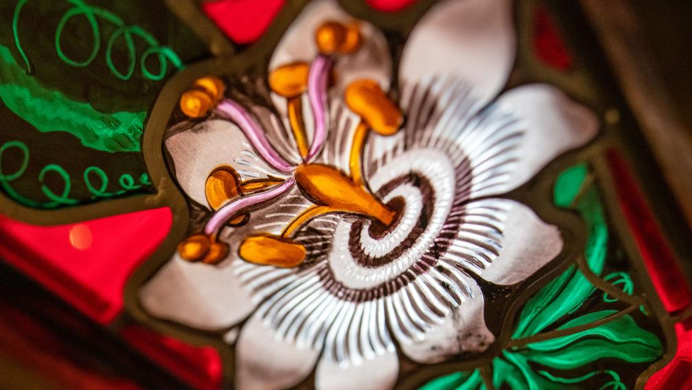 A white flower depicted in a stained-glass window at Trinity Church