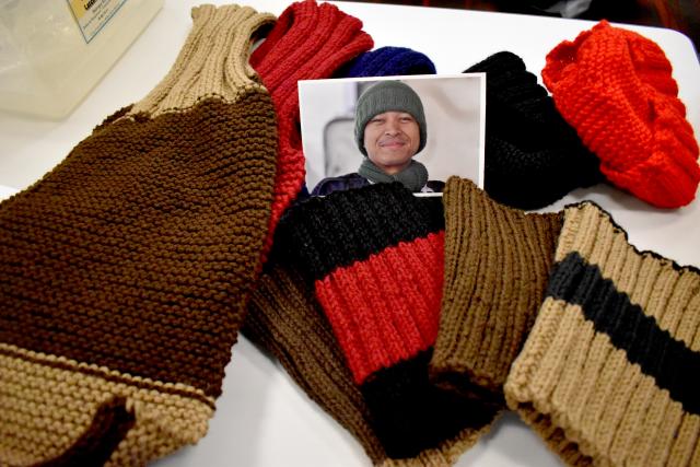 Knitted gifts in brown and red surround a photo of one of the grateful recipients.