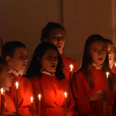 Trinity Youth Chorus members in red performing at Compline by Candlelight