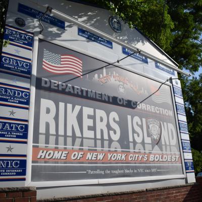 A sign that reads, "Department of Corrections: Rikers Island. Home of New York City's Boldest."