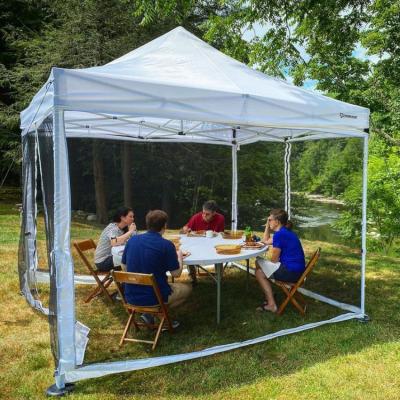 Four guests eat a socially-distanced lunch in a tent near the Housatonic River
